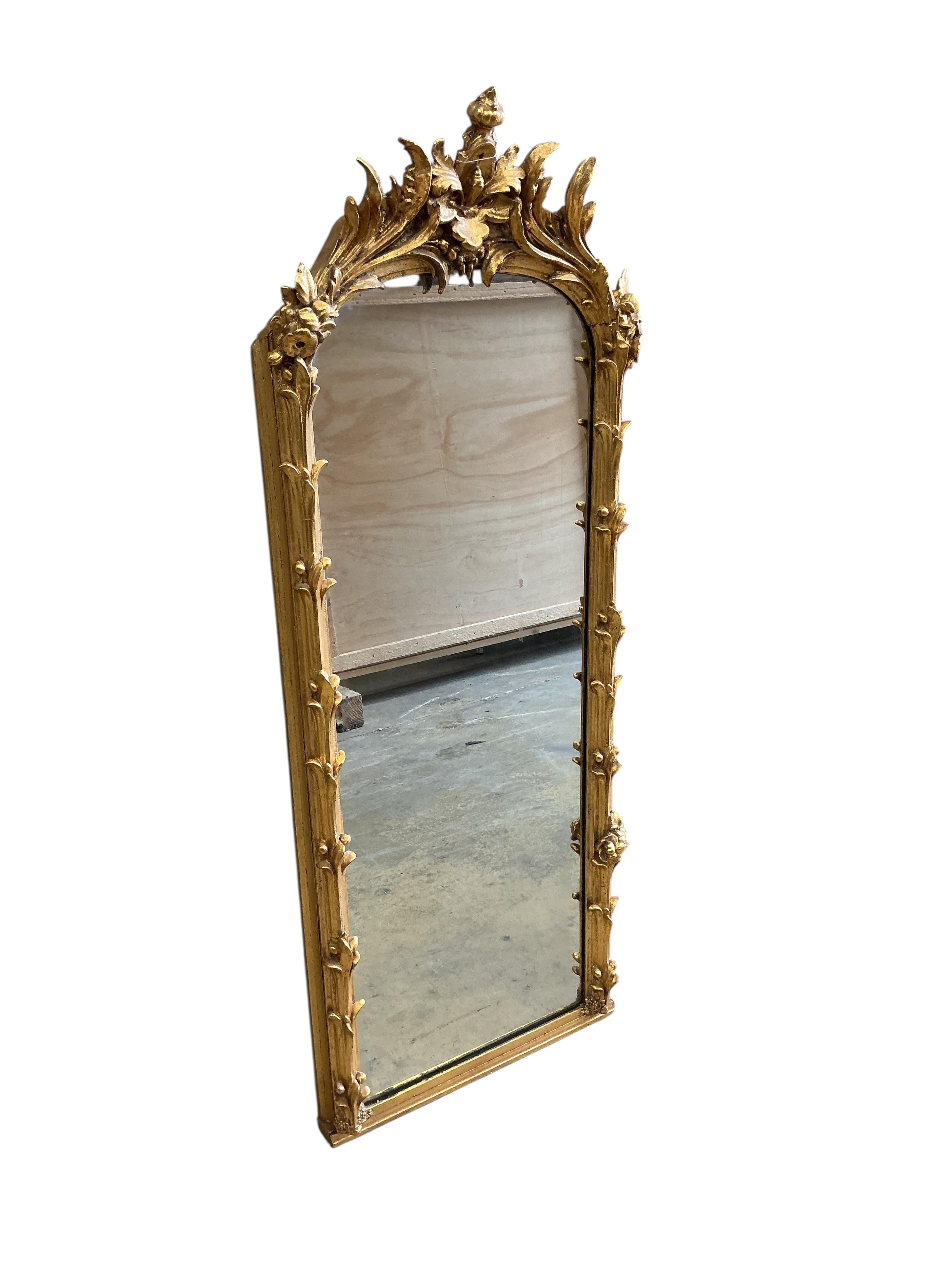 A 19th century carved giltwood and composition wall mirror, re-guilded, width 48cm, height 126cm